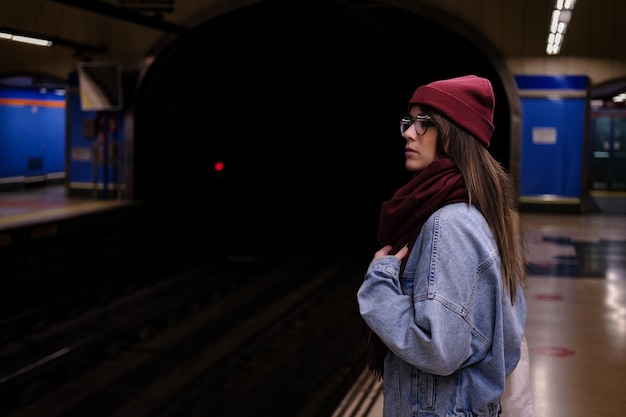 Imagen horizontal de niña esperando el metro