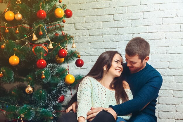 Imagen horizontal de pareja coqueteando entre sí en Nochevieja. Humor navideño.