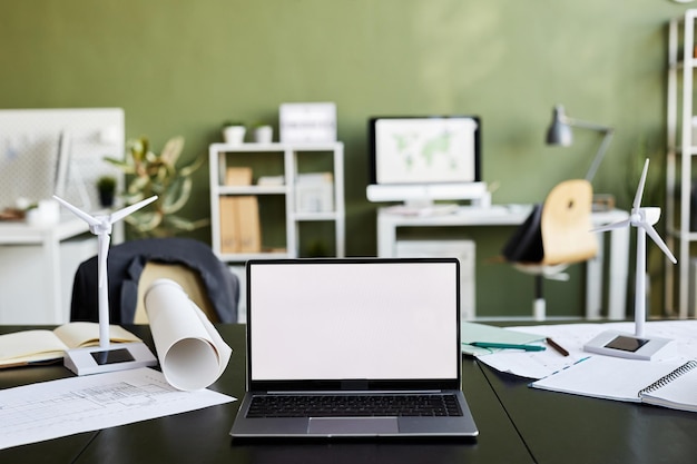 Imagen horizontal del portátil con pantalla vacía en la mesa del arquitecto en la oficina moderna