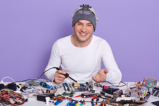 Imagen interior del ingeniero electrónico feliz mirando directamente a la cámara