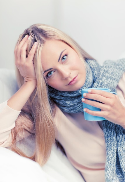 imagen interior de mujer enferma con taza de té