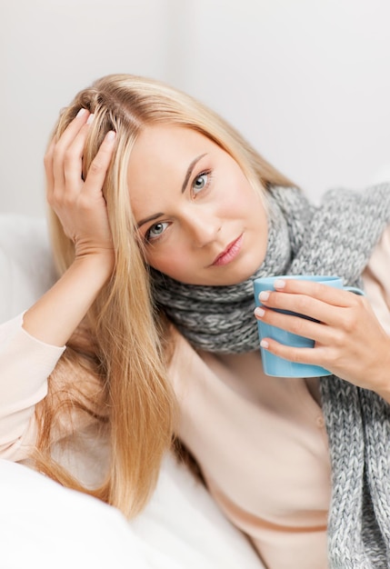 imagen interior de mujer enferma con taza de té