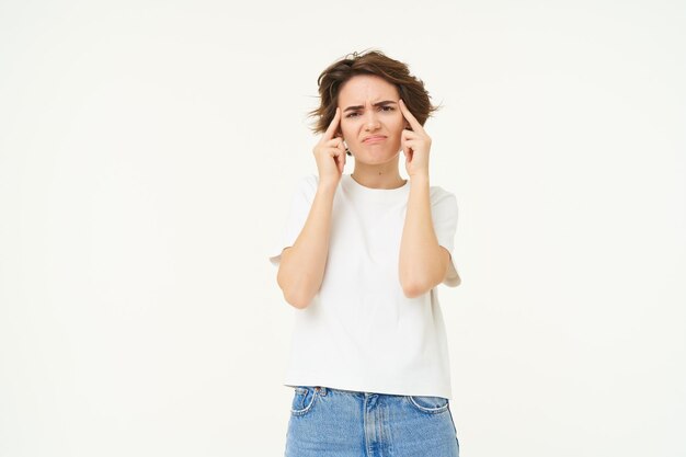 Foto imagen de una joven angustiada y molesta que toca su cabeza tiene dolor de cabeza y sufre de migraña