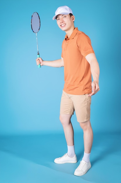 Imagen de un joven asiático sosteniendo una raqueta de bádminton