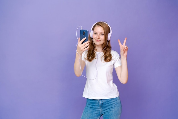 Imagen de una joven emocionada feliz escuchando música con auriculares