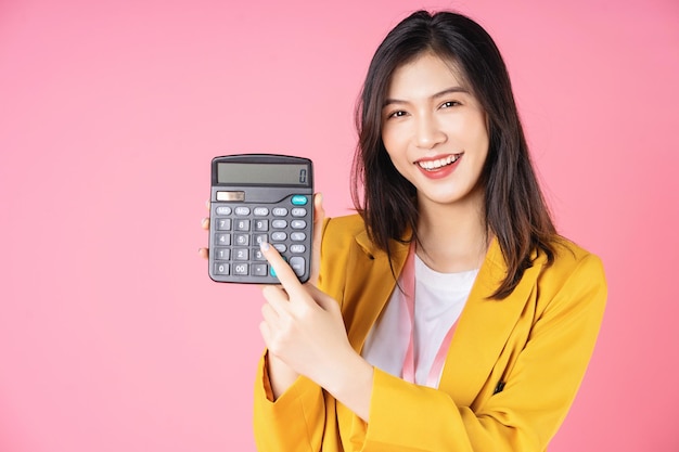 Imagen de una joven empresaria asiática usando una calculadora