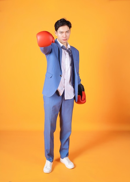 Imagen del joven empresario de ira asiática con guante de boxeo