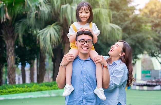 Imagen de una joven familia asiática jugando juntos en el parque