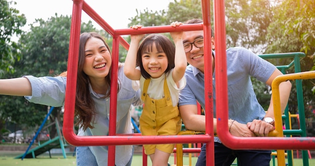 Imagen de una joven familia asiática jugando juntos en el parque