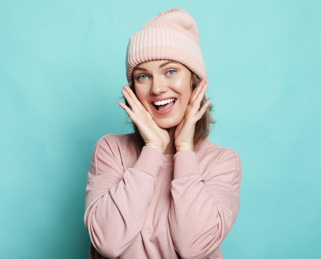 Imagen de una joven feliz con sombrero rosa y suéter