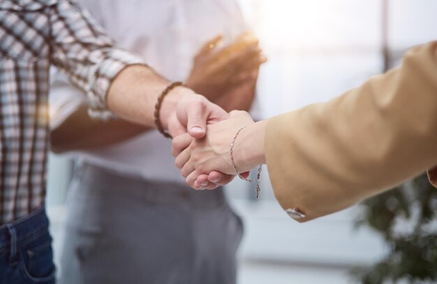 Imagen de una joven mujer de negocios estrechando la mano de un colega.