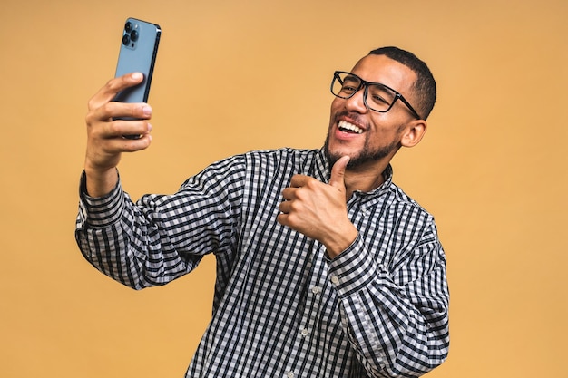 La imagen de un joven negro afroamericano feliz se toma una selfie por teléfono