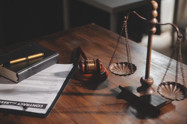 Imagen de jueces balanzas martillo dama de la justicia libro de ley computadora portátil y documentos de contrato con pluma concepto de ley y justicia