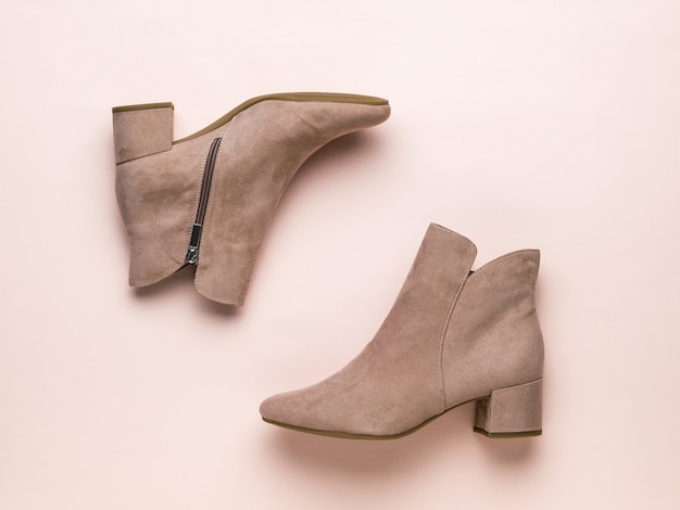 Imagen laica plana de medias botas de mujer beige sobre una superficie beige