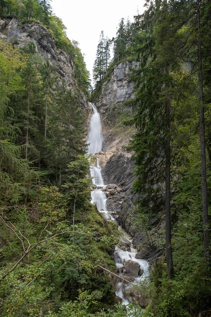 Imagen de larga exposición de una hermosa cascada cayendo por las rocas rodeadas de bosque