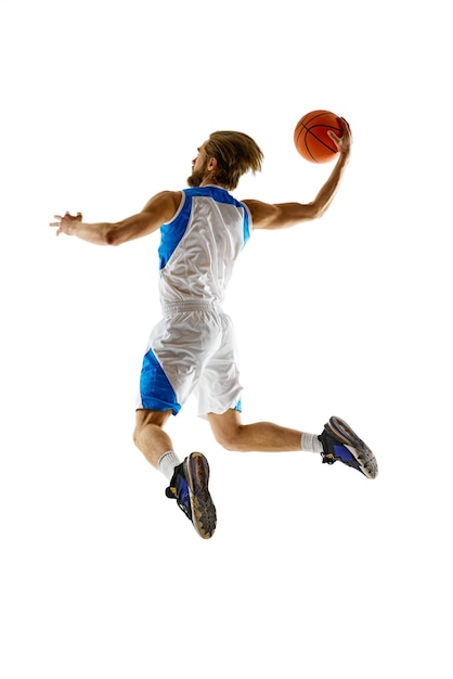 Imagen en longitud completa de un jugador de baloncesto en movimiento practicando entrenamiento aislado en blanco