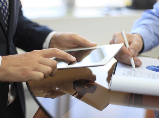 Imagen de la mano humana apuntando a la pantalla táctil en el entorno de trabajo en la reunión