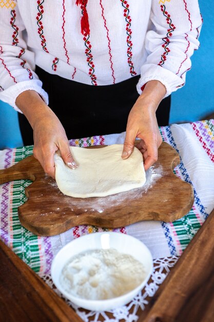 Imagen con las manos de una dama cocinando tradicionales tartas fritas rumanas con queso