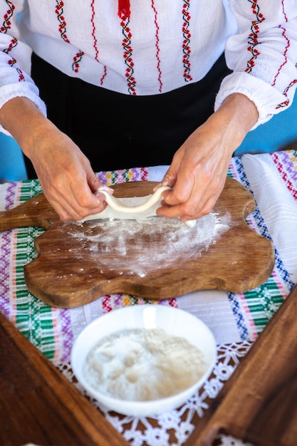 Imagen con las manos de una dama cocinando tradicionales tartas fritas rumanas con queso