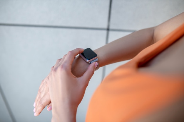 Foto imagen de las manos de una mujer y un reloj inteligente.