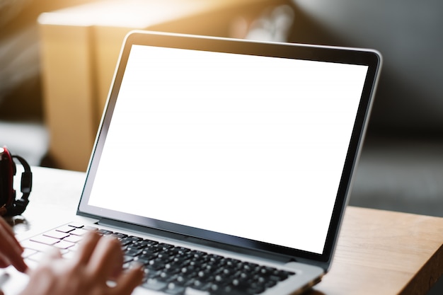 Imagen de la maqueta del hombre de negocios que usa y que pulsa en la computadora portátil con la pantalla blanca en blanco.