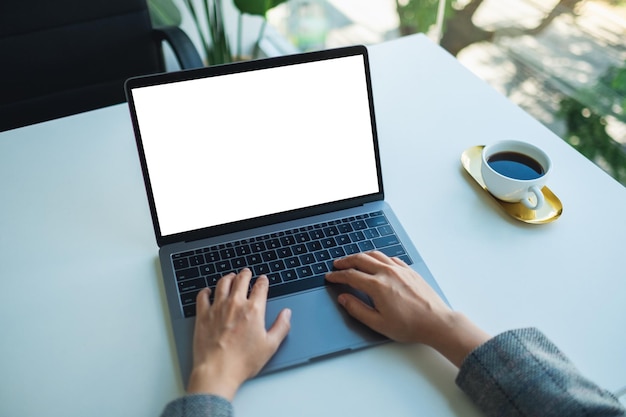 Imagen de maqueta de una mujer de negocios usando y escribiendo en el teclado de una computadora portátil con pantalla de escritorio en blanco en la oficina