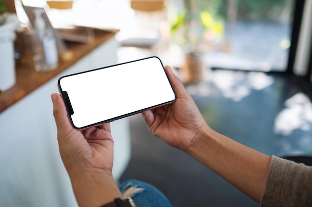 Imagen de maqueta de una mujer que sostiene un teléfono móvil con una pantalla de escritorio en blanco