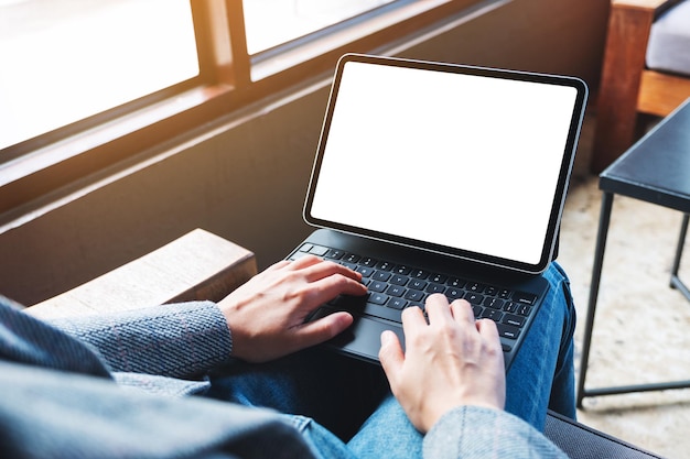 Imagen de maqueta de una mujer que usa y escribe en el teclado de una tableta con una pantalla de escritorio en blanco como una computadora