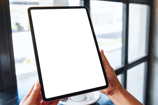 Imagen de maqueta de una mujer sosteniendo una tablet pc negra con una pantalla de escritorio blanca en blanco