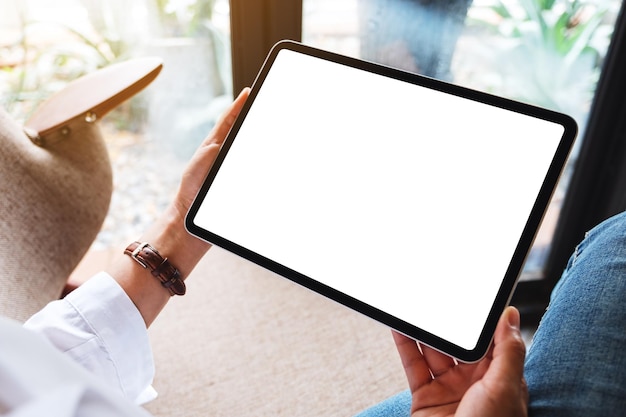 Imagen de maqueta de una mujer sosteniendo una tablet pc negra con una pantalla de escritorio blanca en blanco