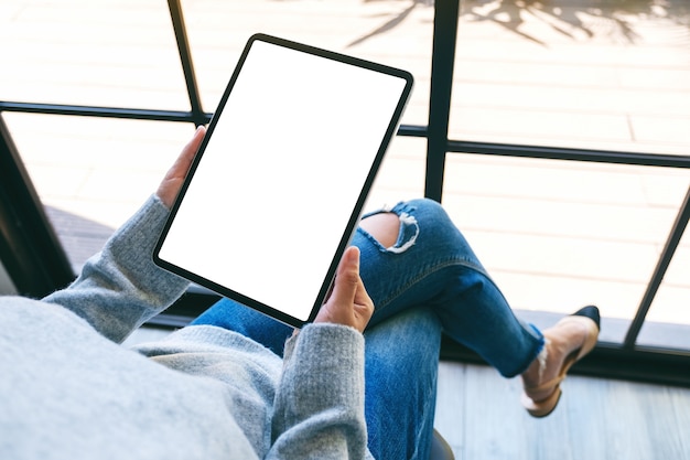 Imagen de maqueta de una mujer sosteniendo tablet pc negro con pantalla en blanco en blanco