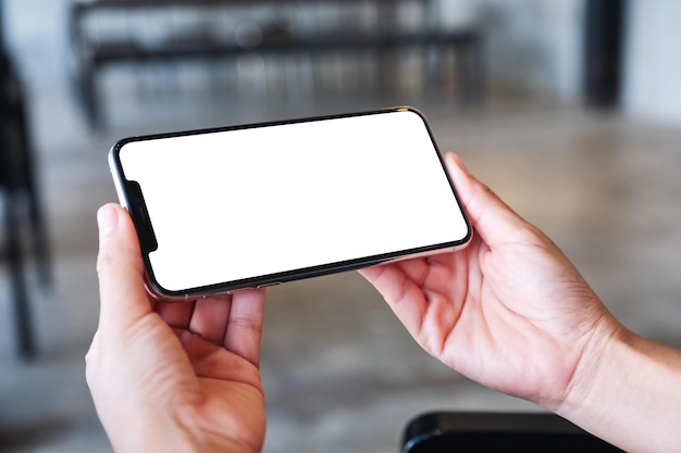 Imagen de maqueta de una mujer sosteniendo un teléfono móvil con una pantalla de escritorio en blanco