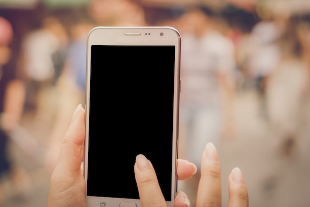 Imagen de maqueta de una mujer sosteniendo y utilizando un teléfono inteligente blanco con pantalla en negro