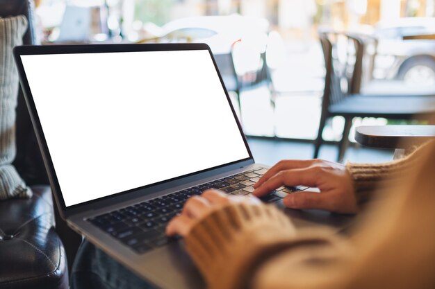 Imagen de maqueta de una mujer usando y escribiendo en una computadora portátil con pantalla de escritorio en blanco en blanco