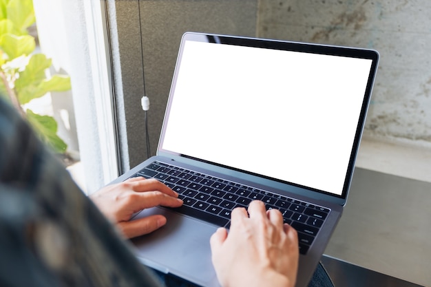 Imagen de maqueta de una mujer usando y escribiendo en una computadora portátil con pantalla de escritorio en blanco en blanco