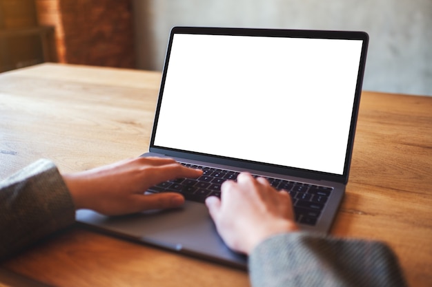 Imagen de maqueta de una mujer usando y escribiendo en una computadora portátil con pantalla de escritorio en blanco en blanco