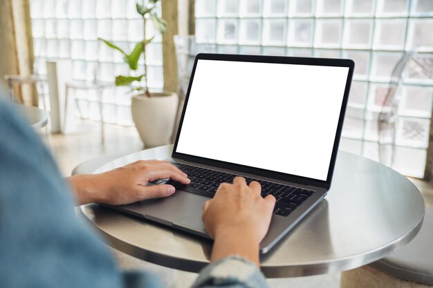 Imagen de maqueta de una mujer usando y escribiendo en una computadora portátil con pantalla de escritorio en blanco en blanco