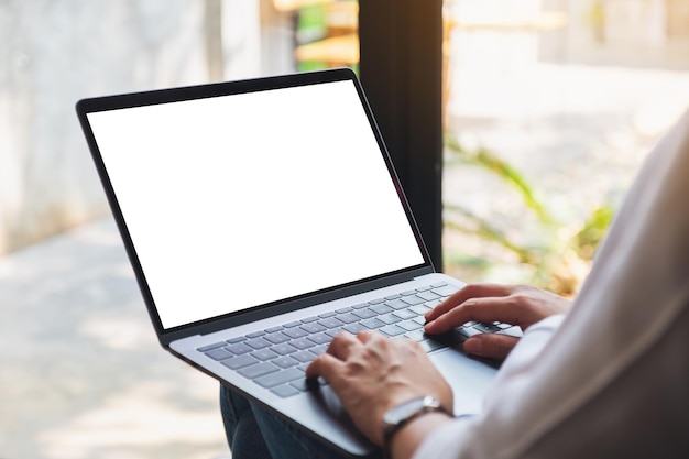 Imagen de maqueta de una mujer usando y escribiendo en una computadora portátil con pantalla de escritorio en blanco en blanco