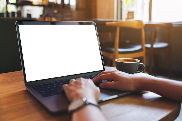 Imagen de maqueta de una mujer usando y escribiendo en una computadora portátil con pantalla de escritorio en blanco en el café