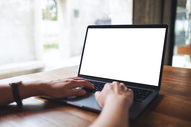 Imagen de maqueta de una mujer usando y escribiendo en una computadora portátil con pantalla de escritorio en blanco en el café