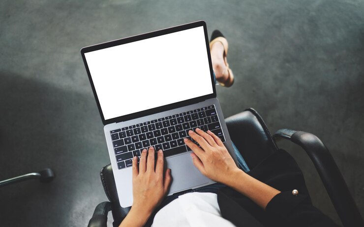 Foto imagen de maqueta de vista superior de una mujer de negocios usando y escribiendo en una computadora portátil con pantalla de escritorio en blanco en la oficina