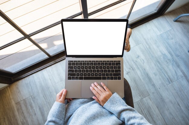 Imagen de maqueta de vista superior de una mujer usando y tocando en el panel táctil de la computadora portátil con pantalla de escritorio blanca en blanco