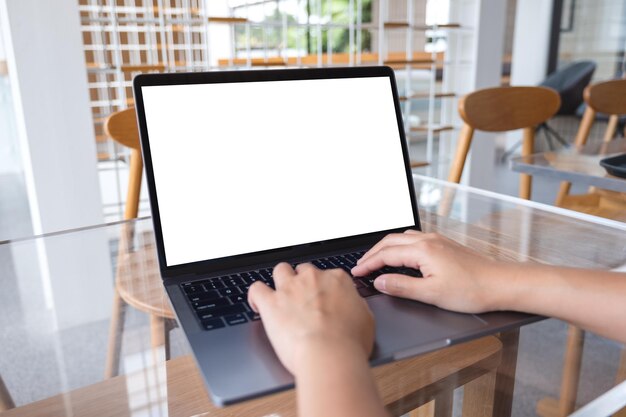 Imagen de maquillaje de una mujer trabajando y escribiendo en una computadora portátil con una pantalla de escritorio blanca en blanco en una cafetería