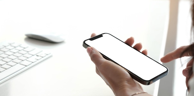 Imagen de maquillaje de pantalla blanca en blanco teléfono celular mujeres con la mano enviando mensajes de texto usando móvil en el escritorio en casa