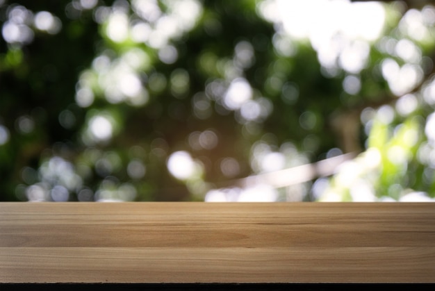 Imagen de la mesa de madera oscura delante de fondo abstracto borrosa de luces de jardín al aire libre. puede ser utilizado para la exhibición o el montaje de sus productos. Mueva para arriba para la exhibición del producto