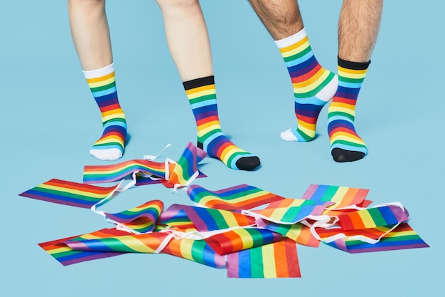 Imagen mínima de una pareja con calcetines de arcoíris con banderas lgbtq en un espacio de copia de fondo azul pastel