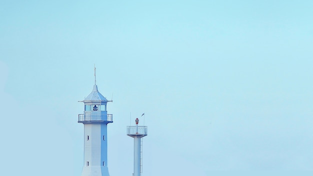 Imagen minimalista del faro sobre fondo azul Papel tapiz con torre en el cielo