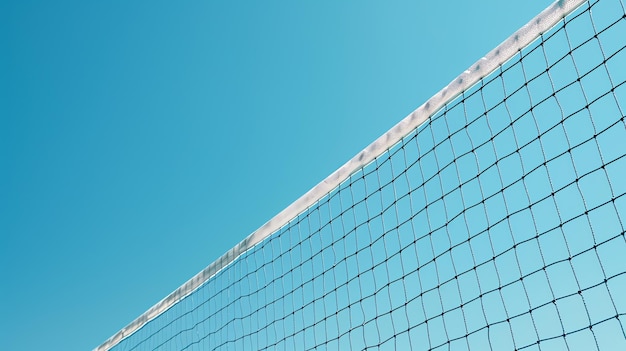 La imagen muestra una red de voleibol contra un cielo azul claro