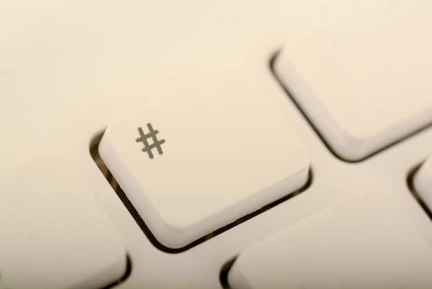 La imagen muestra una tecla de teclado blanca con un símbolo de hashtag en ella