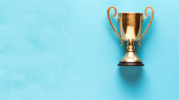 Esta imagen muestra un trofeo dorado sobre un fondo azul El trofeo está en el centro de la imagen y está rodeado de espacio vacío